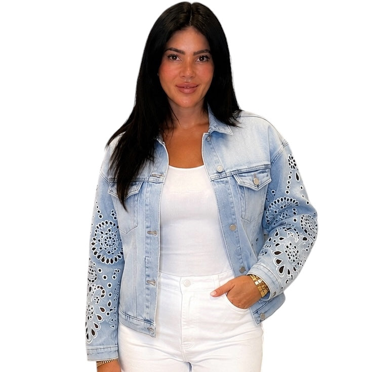 Woman wearing a light blue denim jacket with lace details on a white background