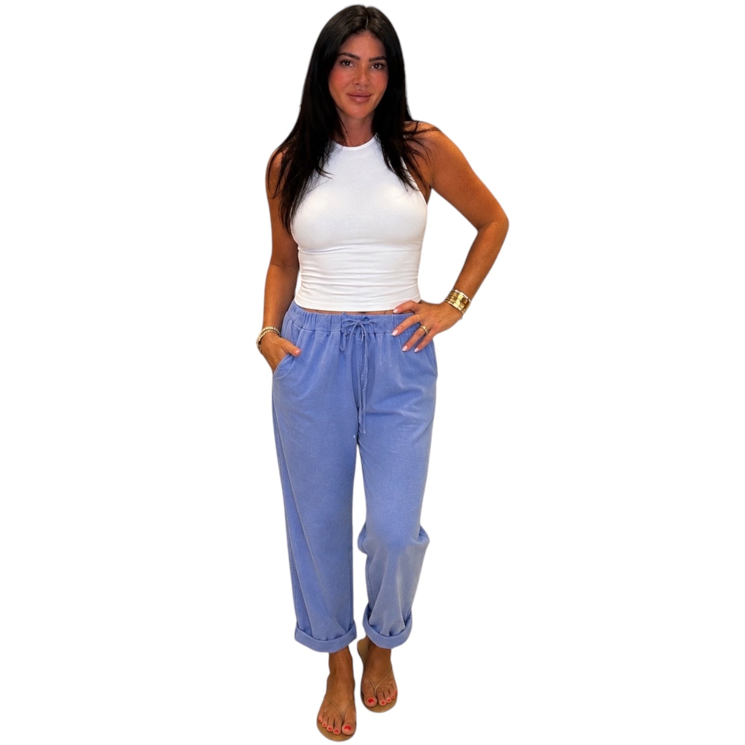 Woman wearing a white top and blue pants on a white background