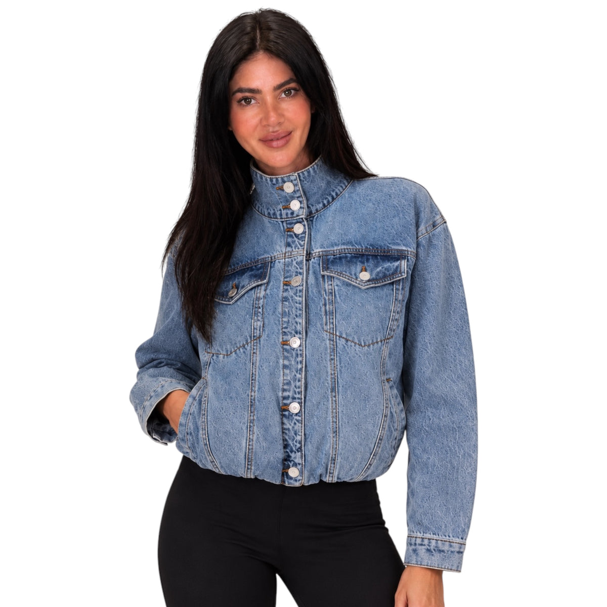 A woman modeling a cropped light blue denim jacket with a high stand-up collar, button front, and chest flap pockets, paired with black pants against a plain white background.