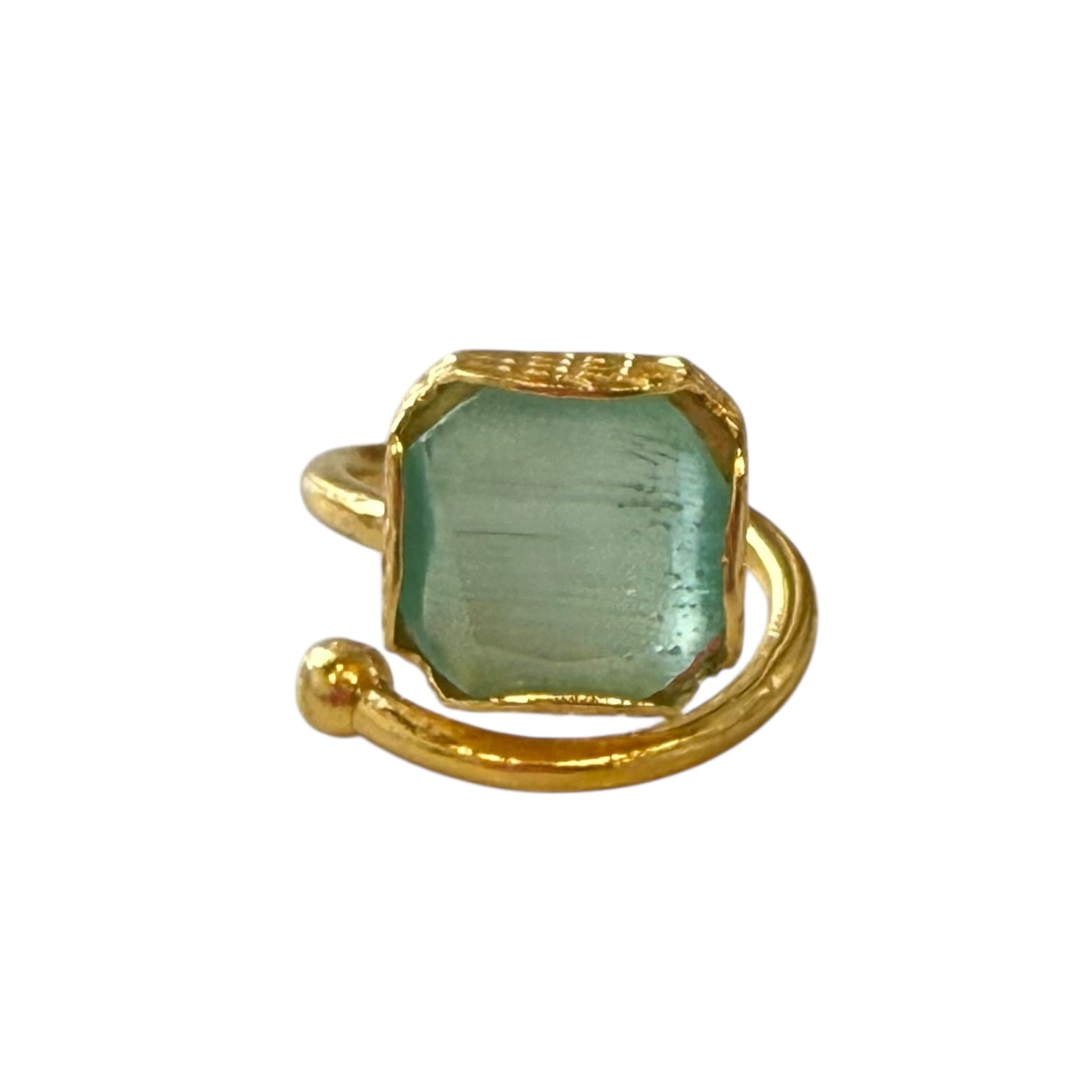Gold ring with a green gemstone on a white background