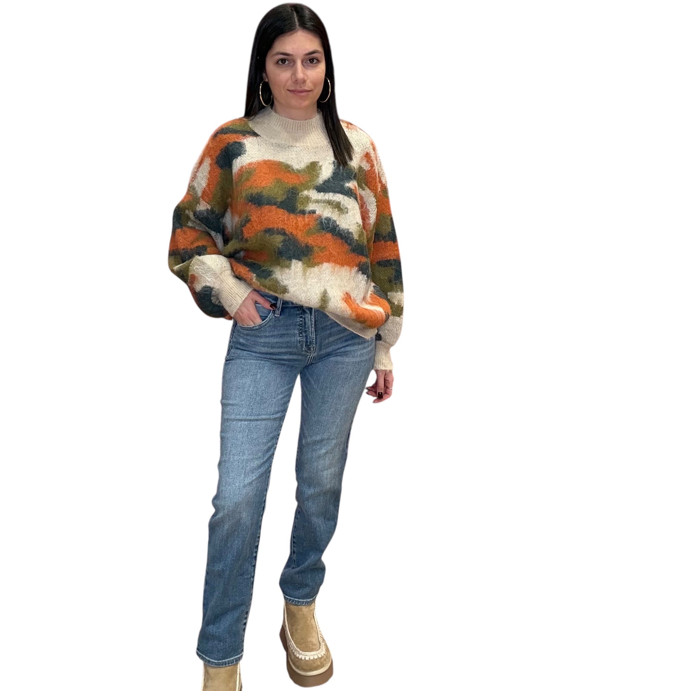 Woman wearing a patterned sweater and jeans on a white background