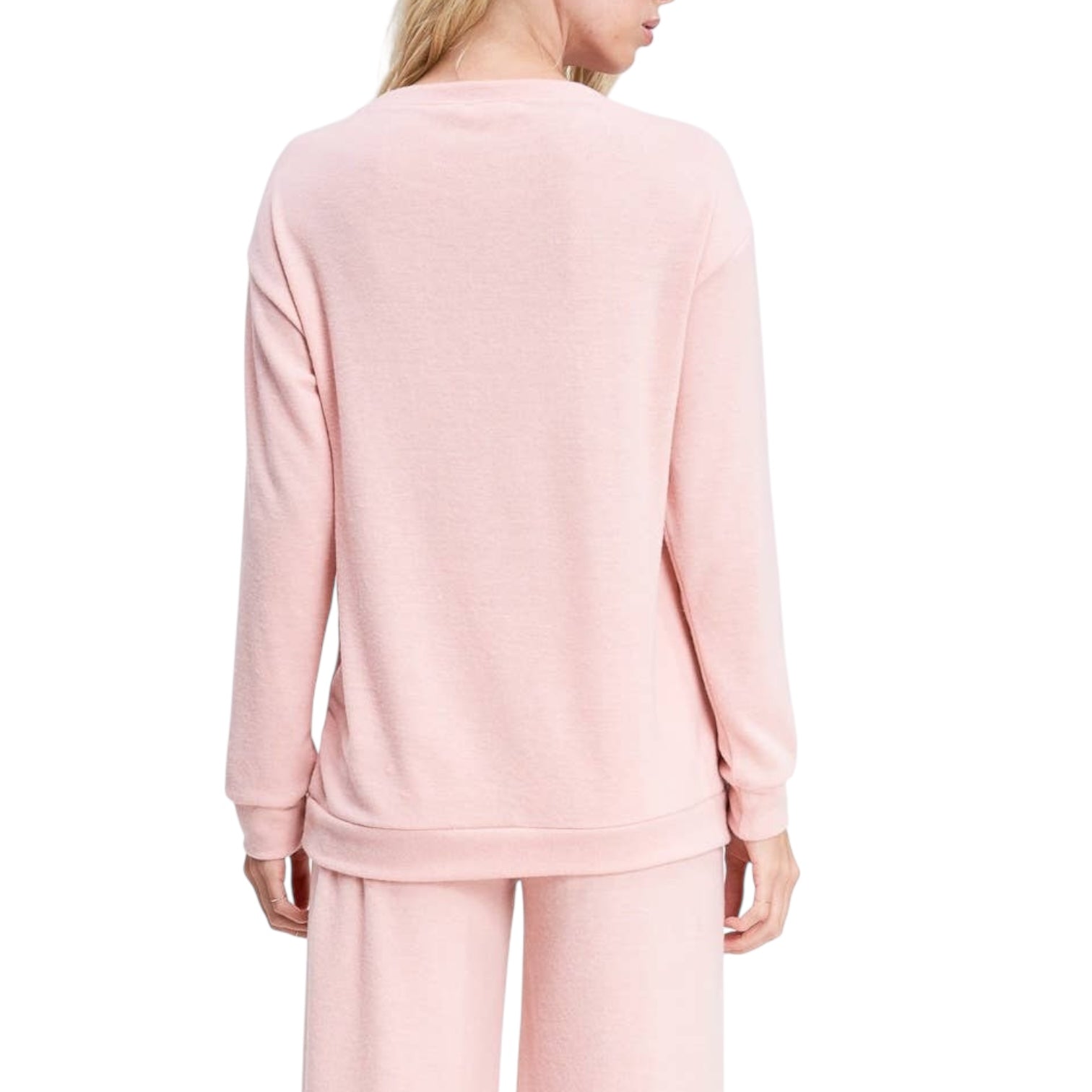 Person wearing a pink top and pants set on a white background