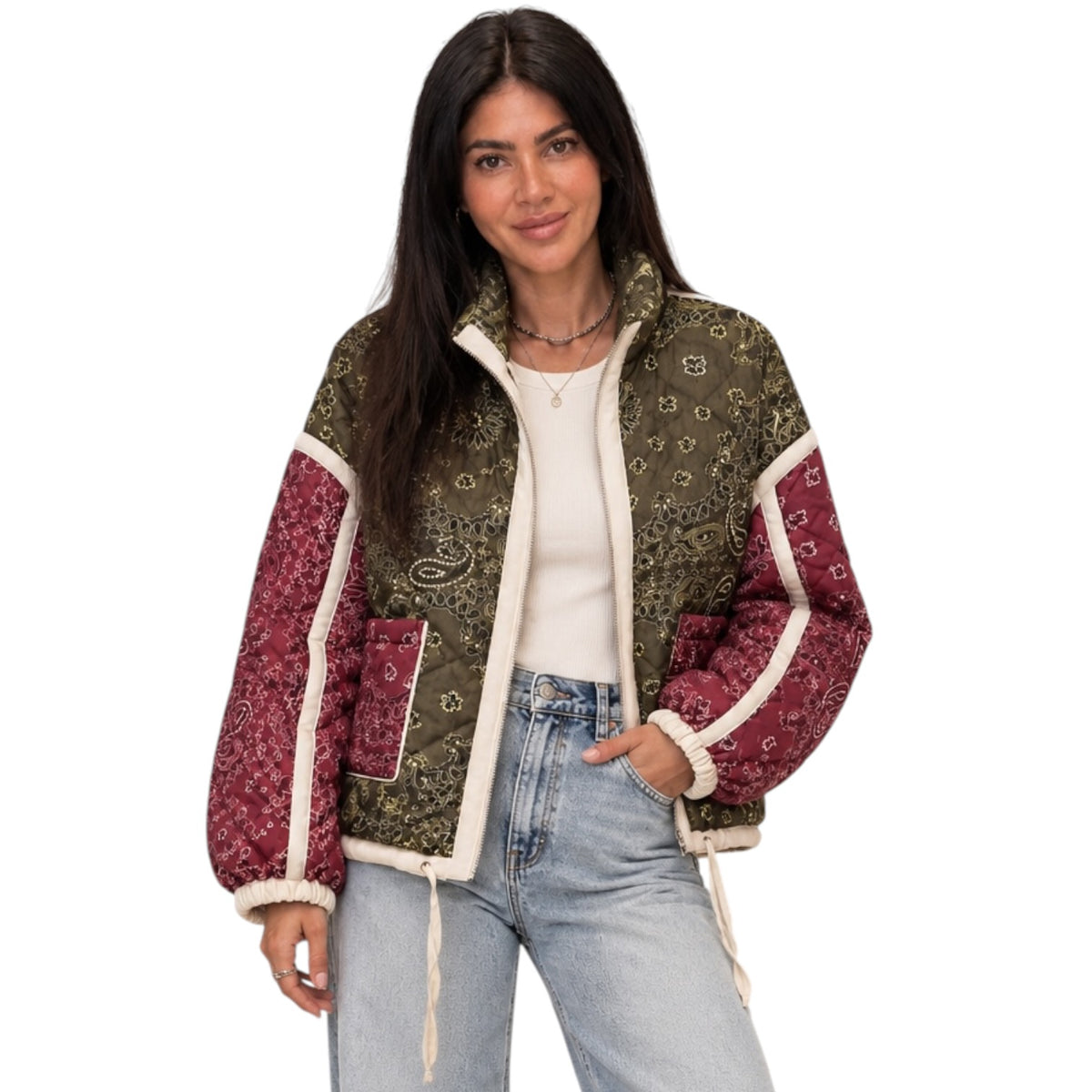A woman modeling a mixed-media jacket with olive green paisley patterned panels, burgundy paisley sleeves and pockets, and cream sherpa lining, paired with a white top and light-wash jeans against a plain white background.