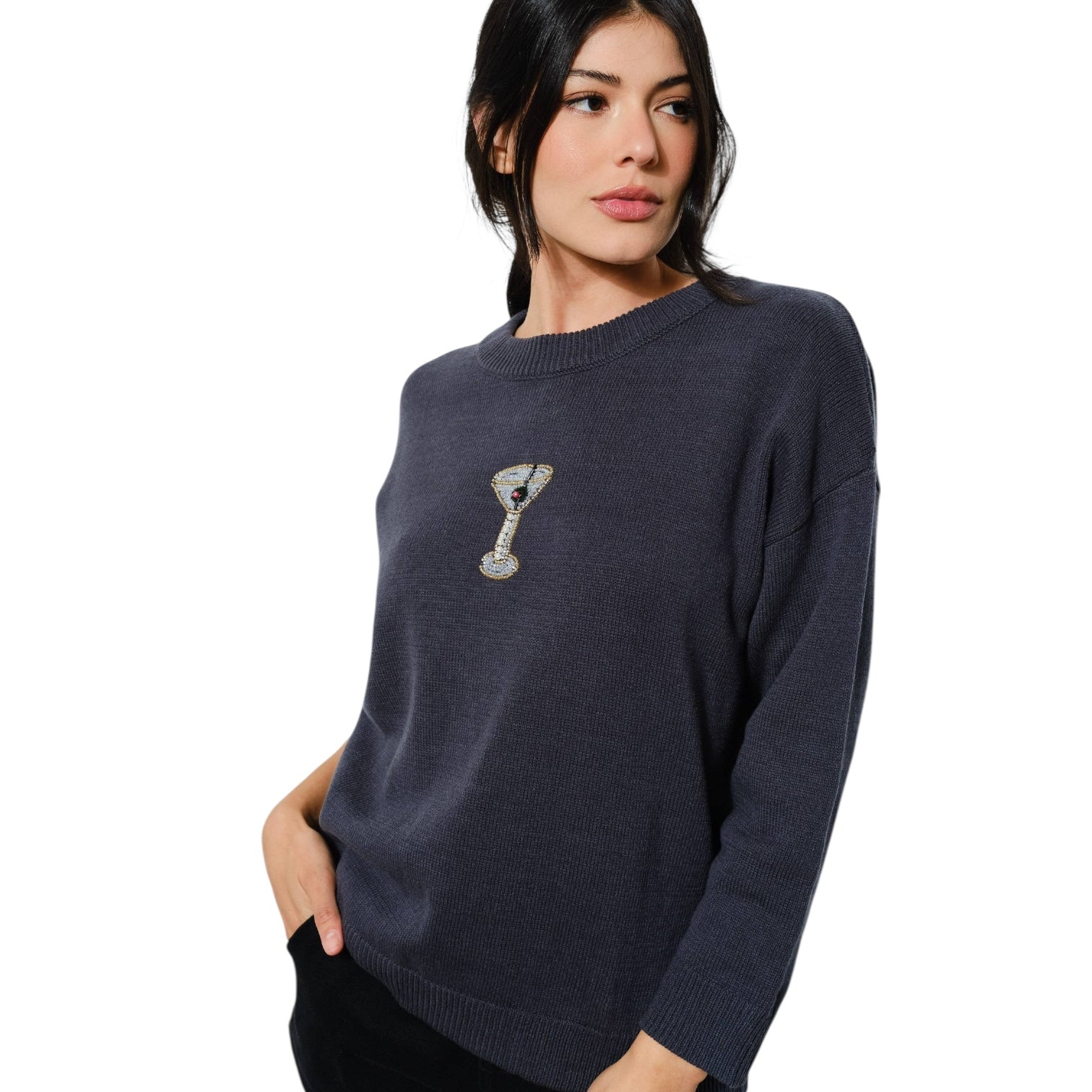 Woman wearing a navy sweater with a martini glass design on a white background