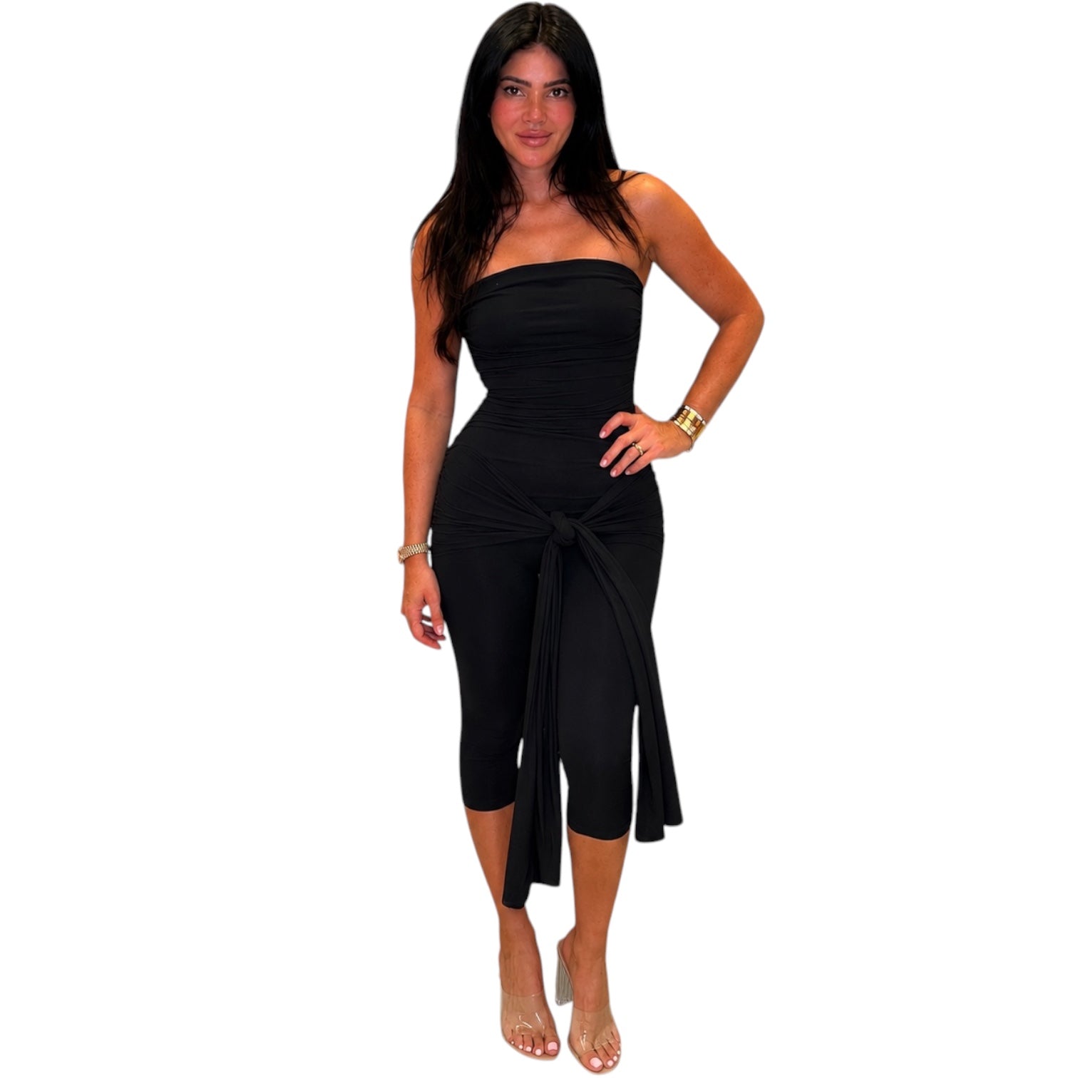 Woman wearing a black strapless jumpsuit on a white background