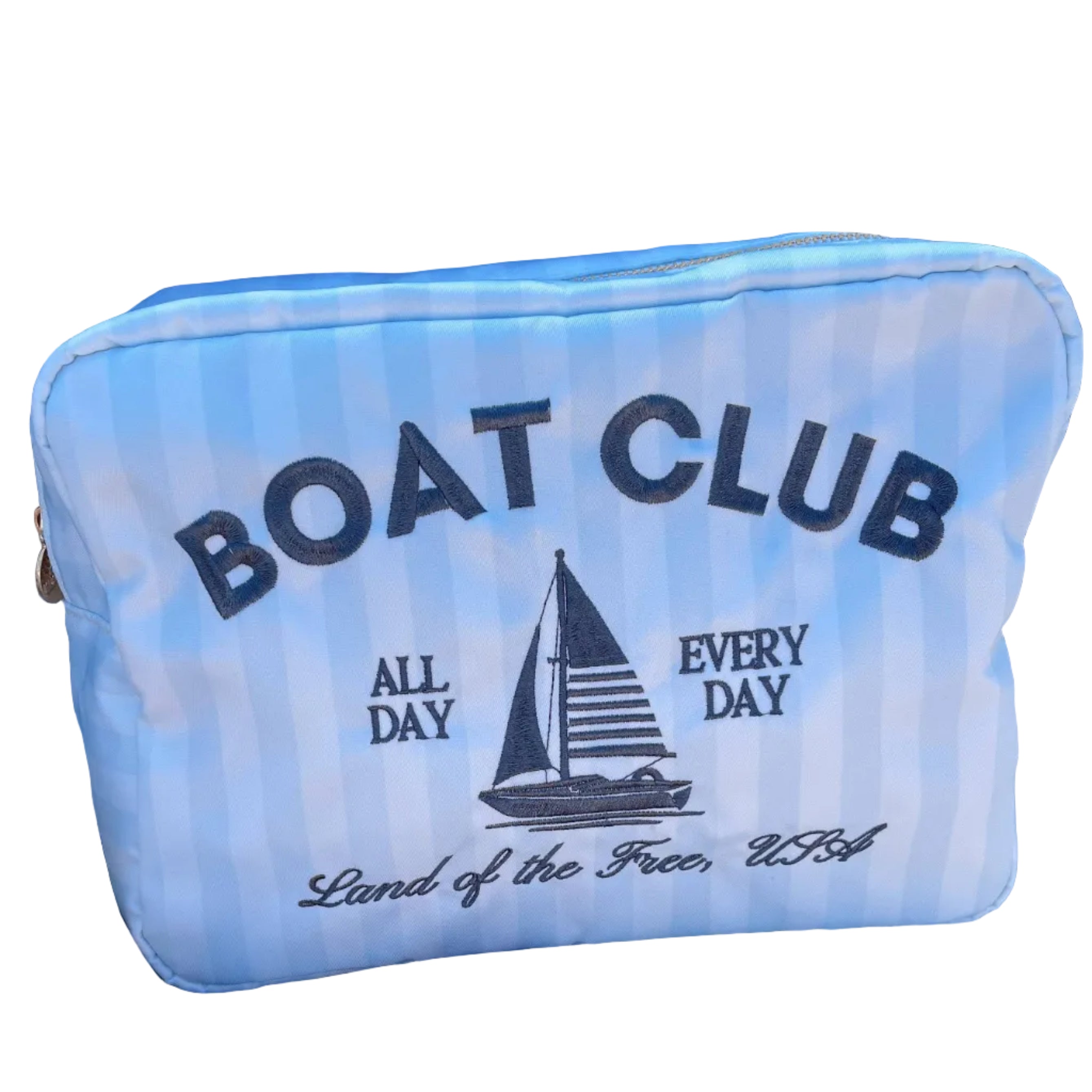 Blue pouch with 'Boat Club' text and sailboat graphic on a white surface with sunglasses and cap.