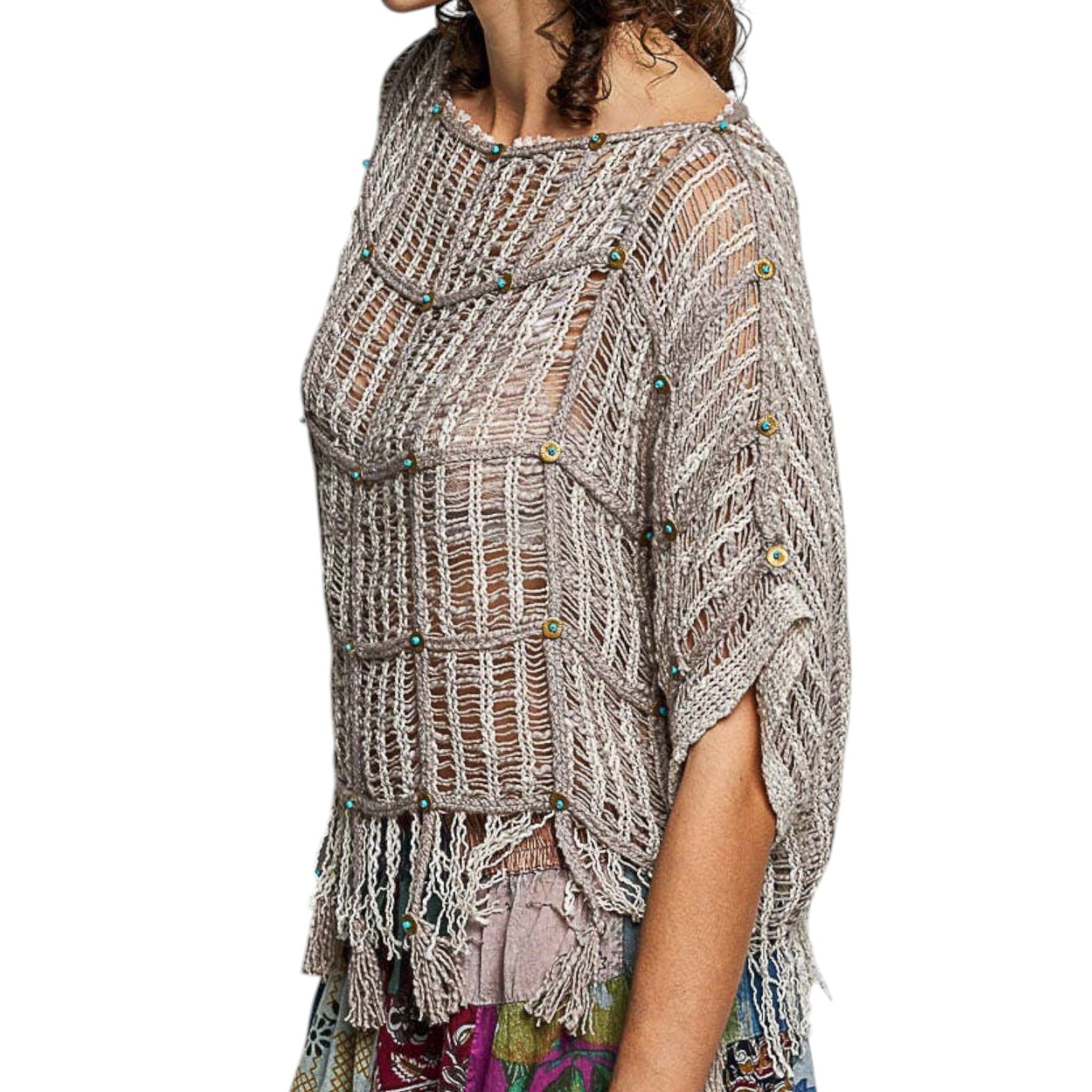 Woman wearing a textured, patterned poncho on a white background