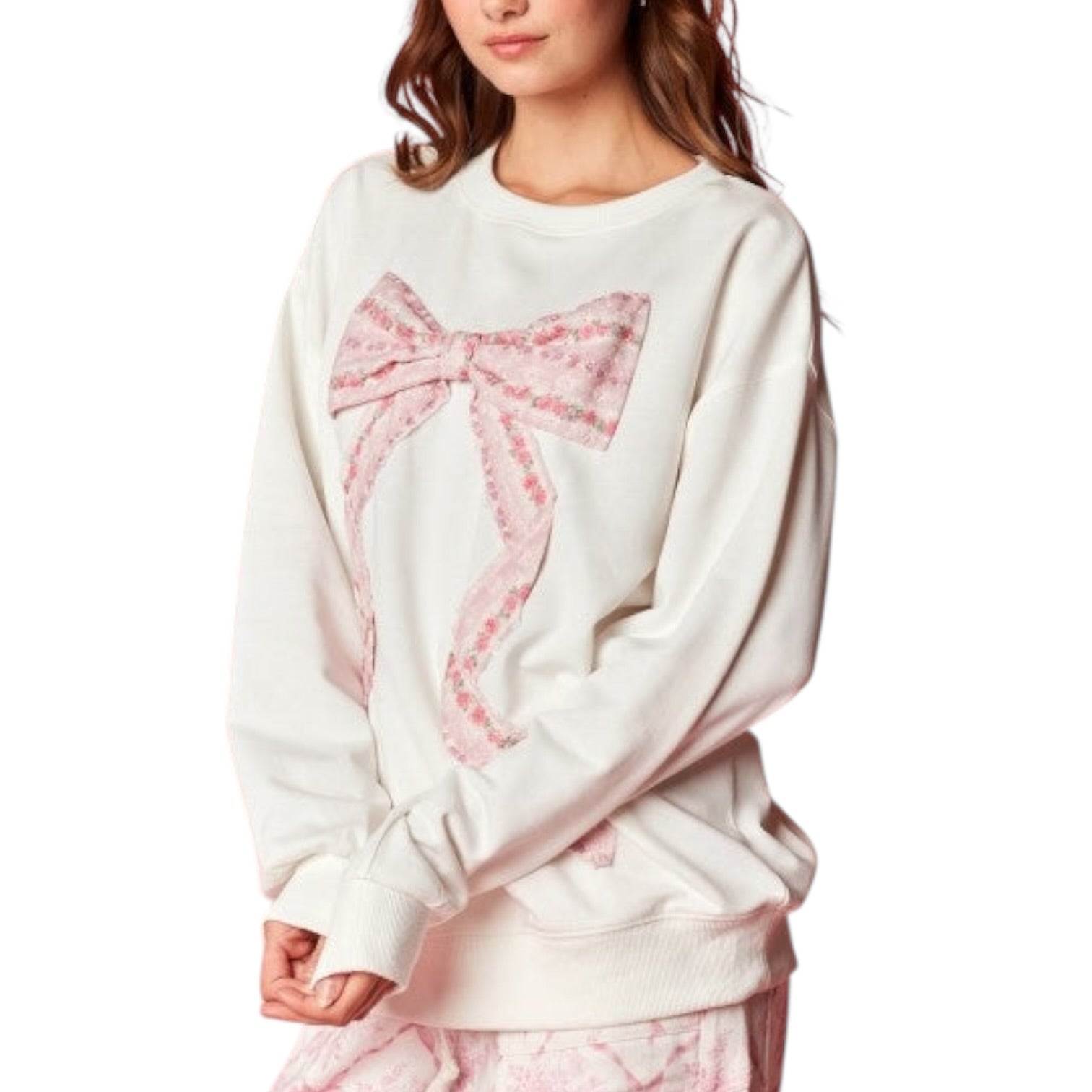 White sweatshirt with a pink bow design worn by a person on a white background