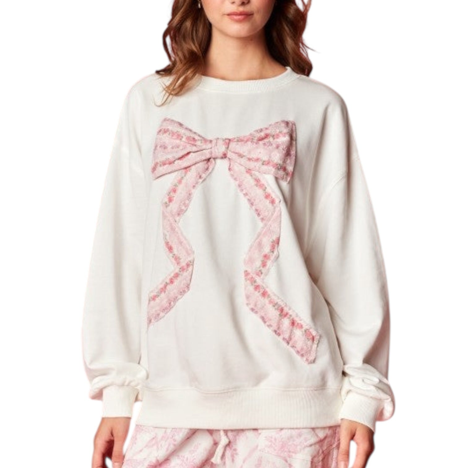 White sweater with a large pink bow design on a white background