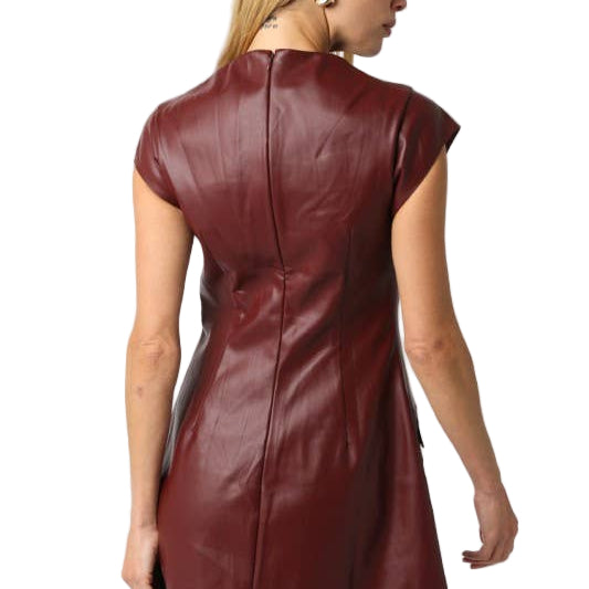 Woman wearing a burgundy leather dress on a white background