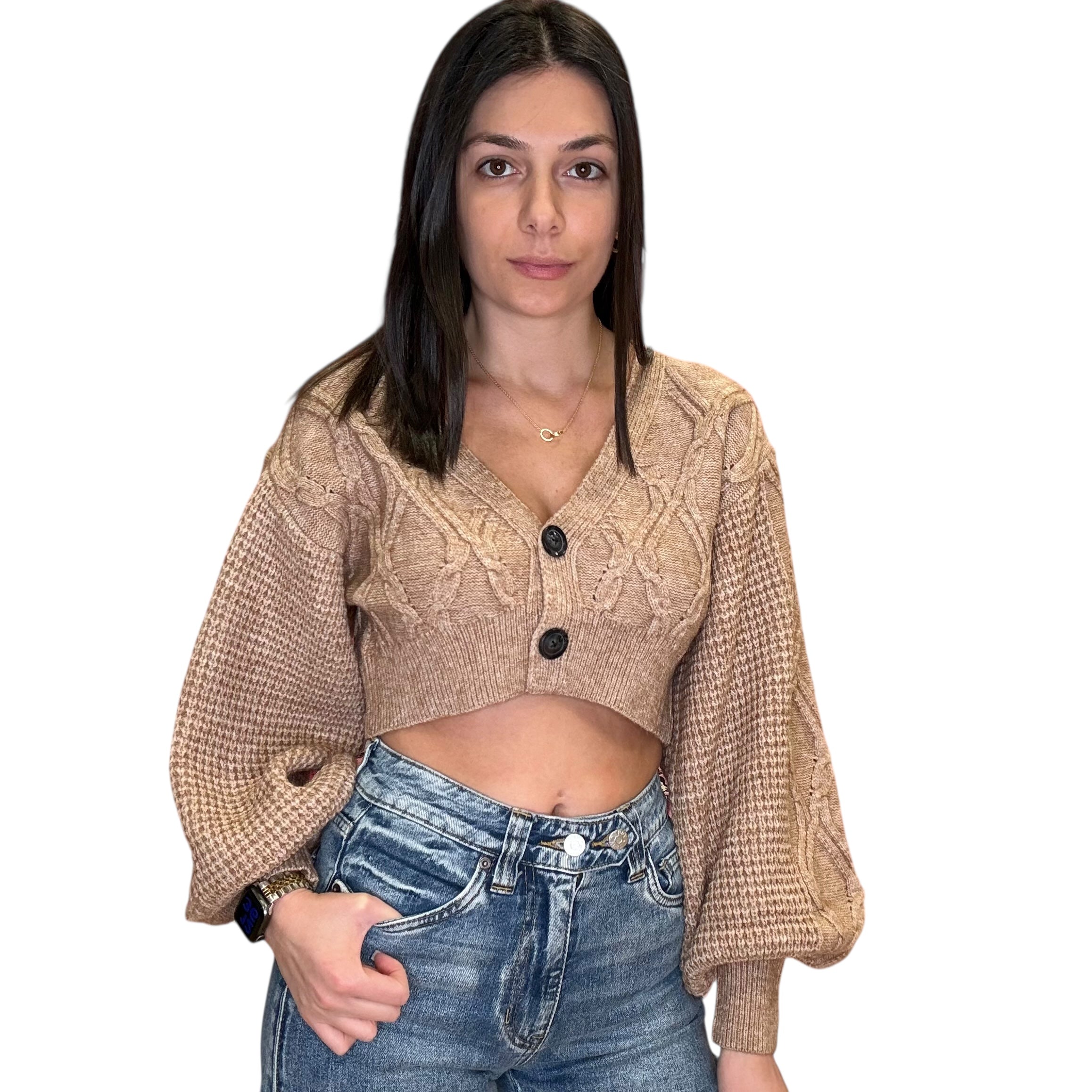 Woman wearing a beige knitted cardigan and blue jeans on a white background