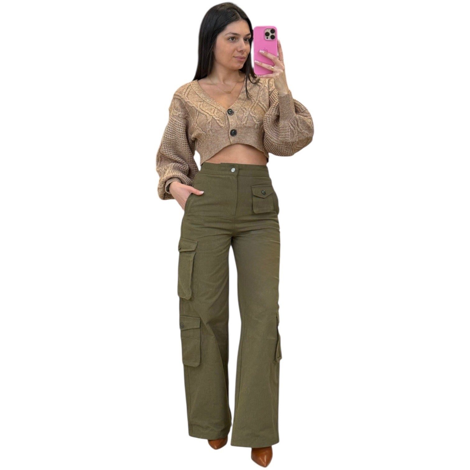 Woman taking a mirror selfie wearing a beige cropped sweater and olive green cargo pants on a white background.