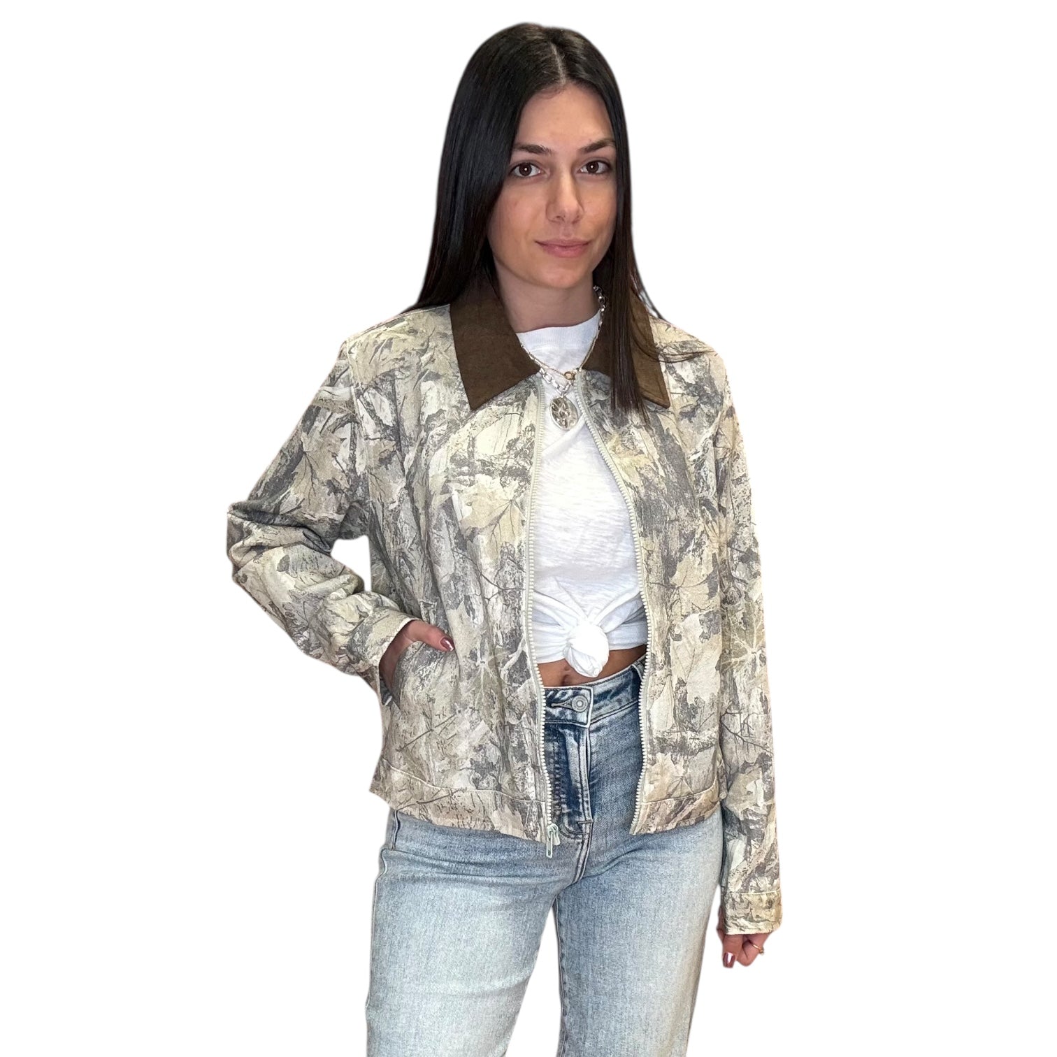 Woman wearing a patterned jacket and jeans on a white background