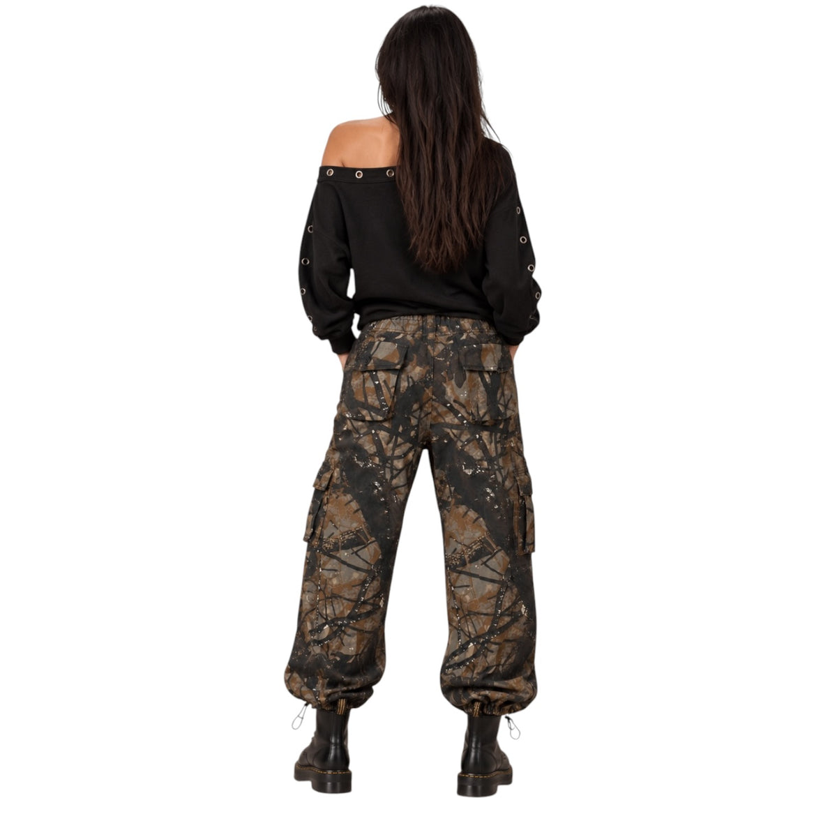 A model shown from the back wearing loose-fitting camouflage cargo pants, a black off-the-shoulder long-sleeve top, and black boots against a plain white background.
