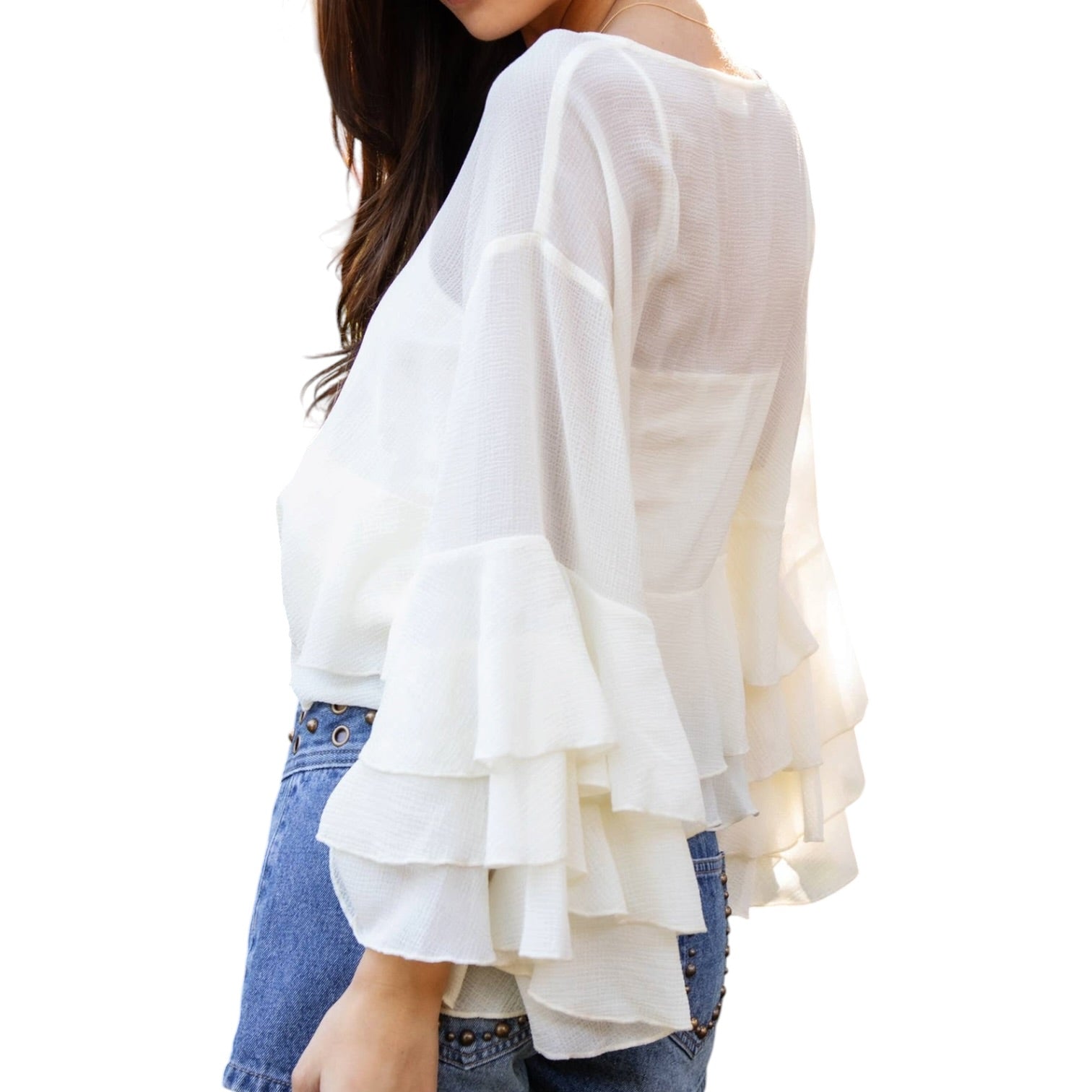 White blouse with ruffled sleeves worn by a person on a white background