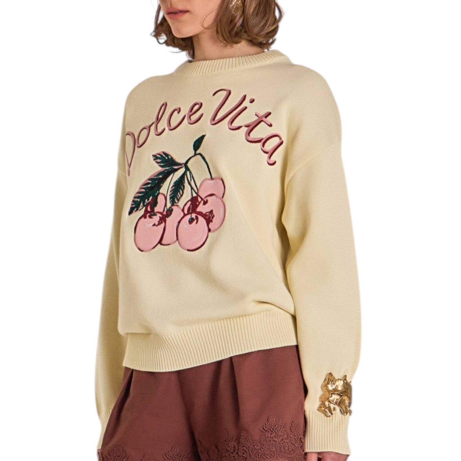 Beige sweater with 'Dolce Vita' and cherry design, worn by a person.