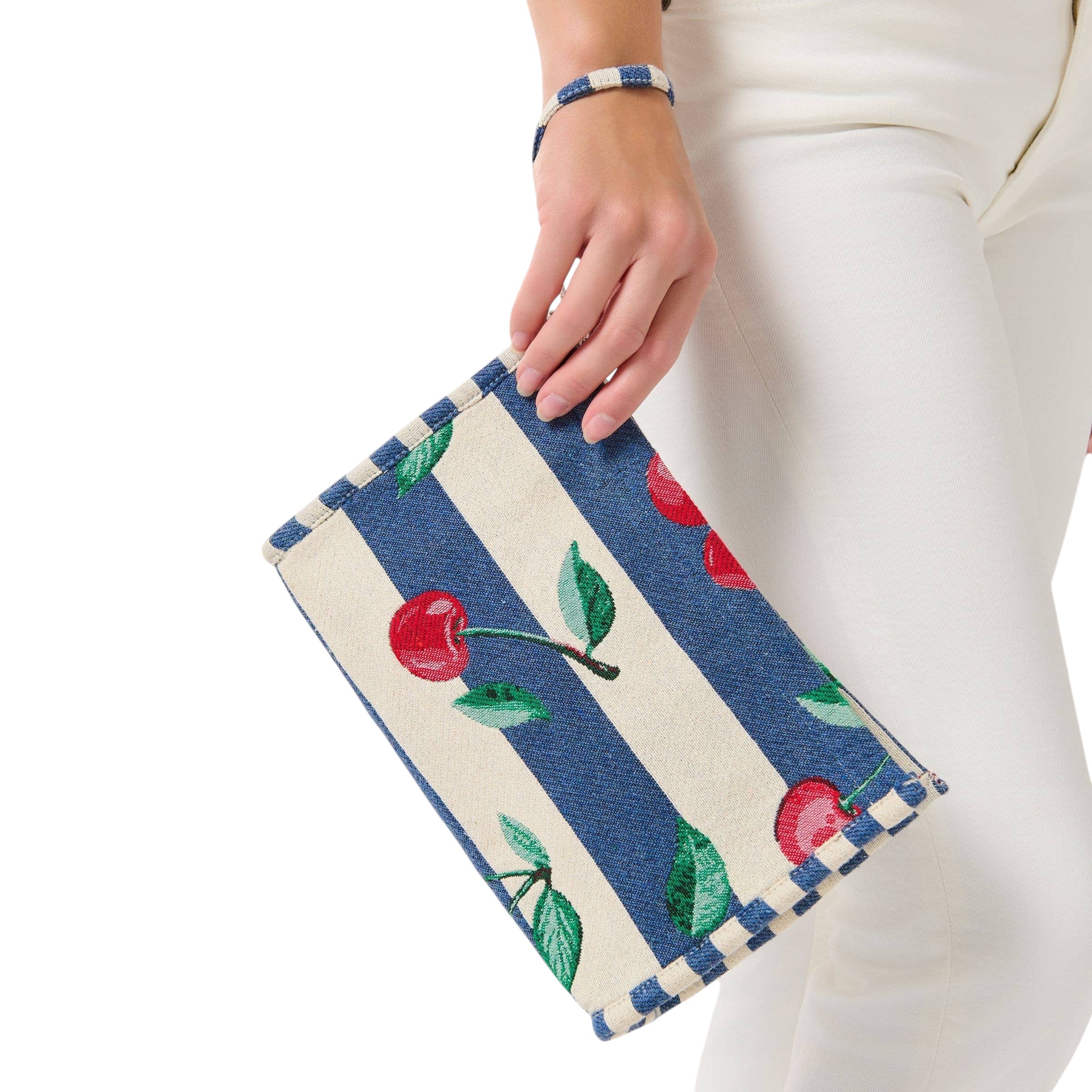 Hand holding a small pouch with cherry pattern on a white background