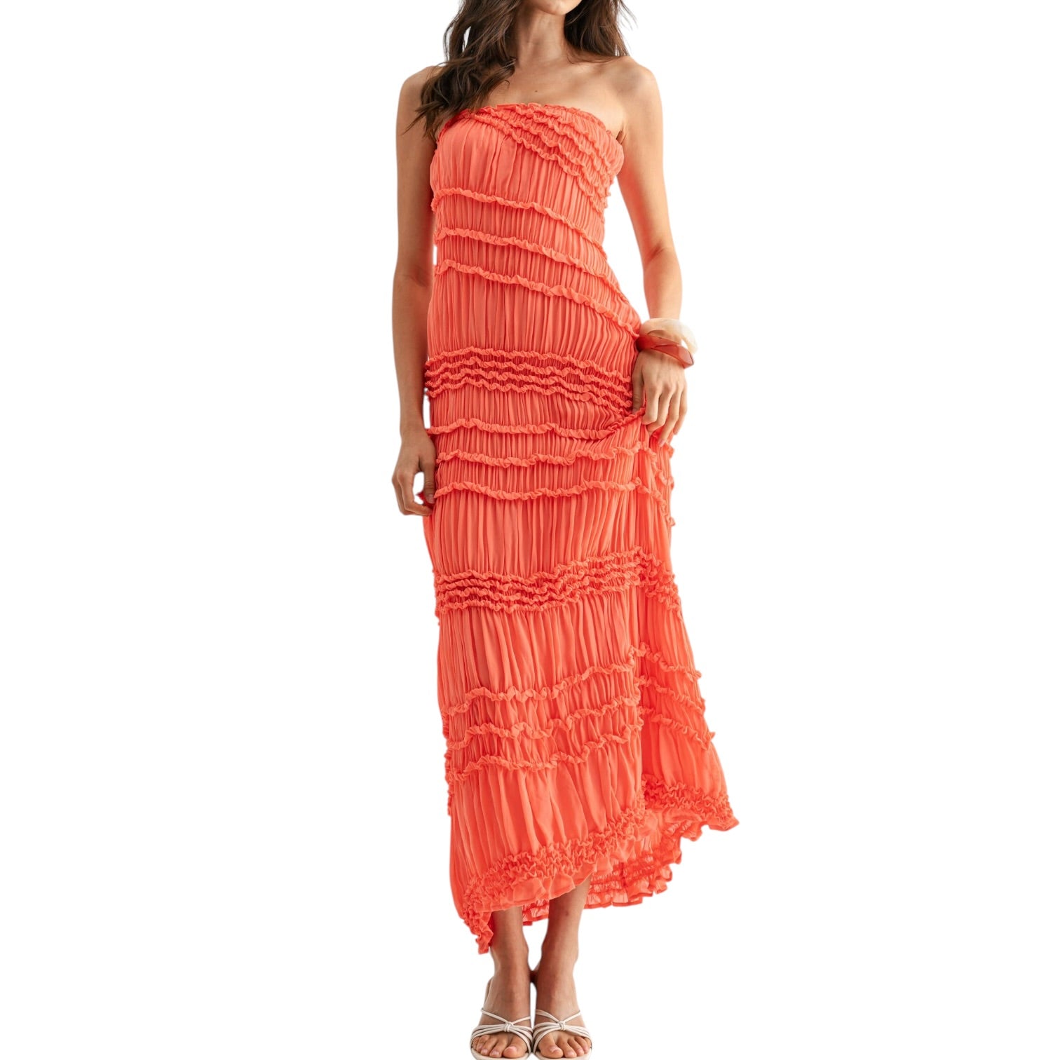 Woman wearing a coral strapless dress on a white background