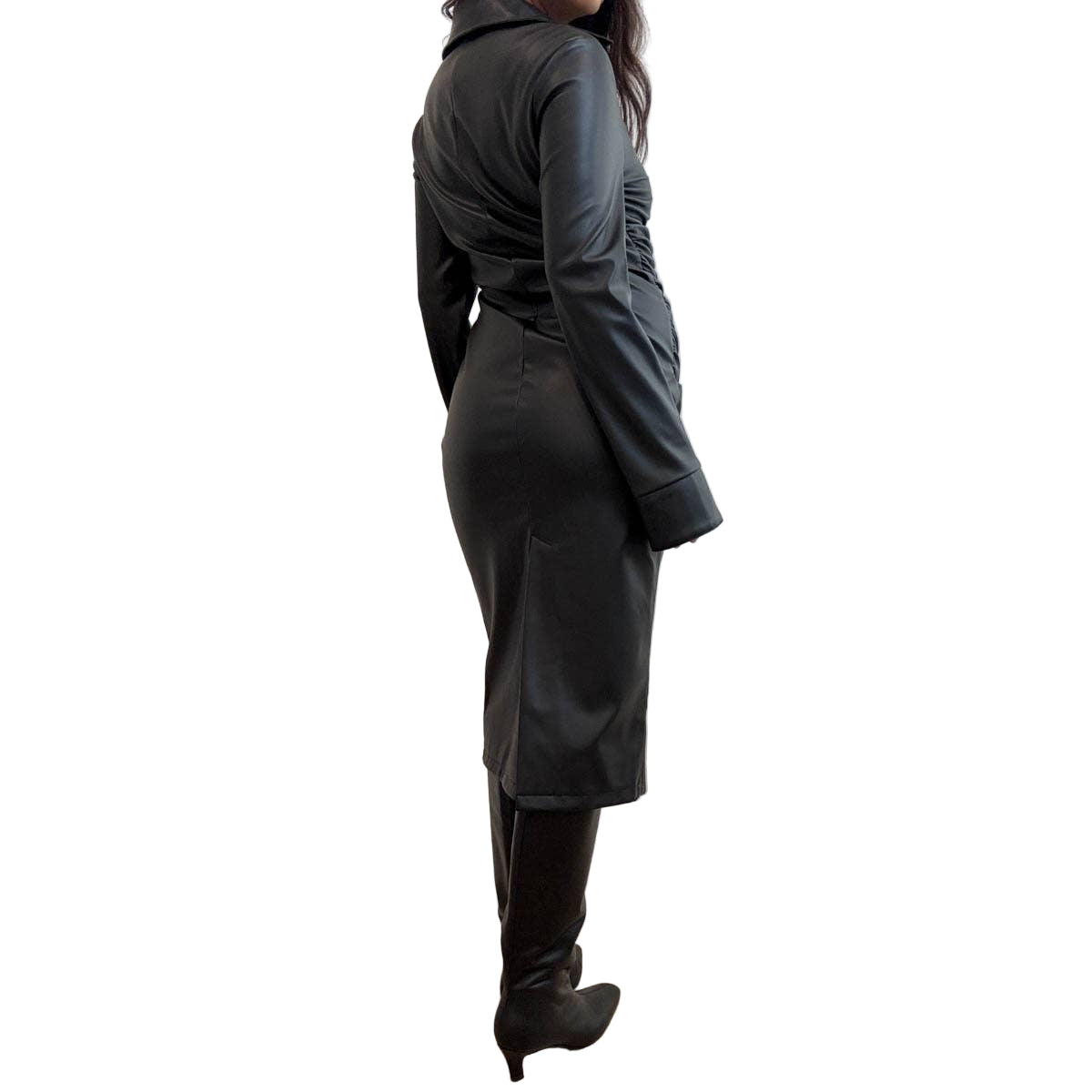 Person wearing a faux leather dress standing against a plain wall.