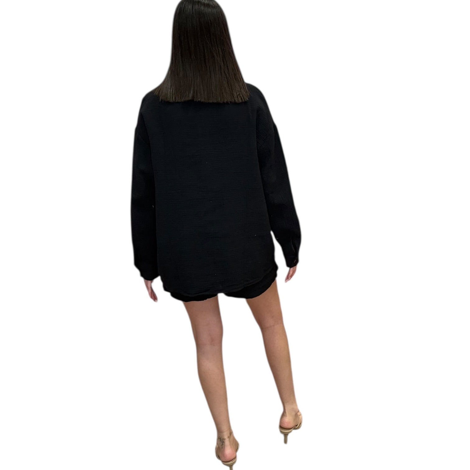 Person wearing a black oversized sweater and shorts on a white background