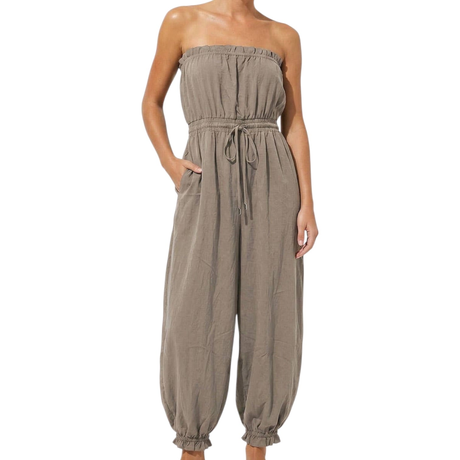 woman wearing taupe jumpsuit on white background