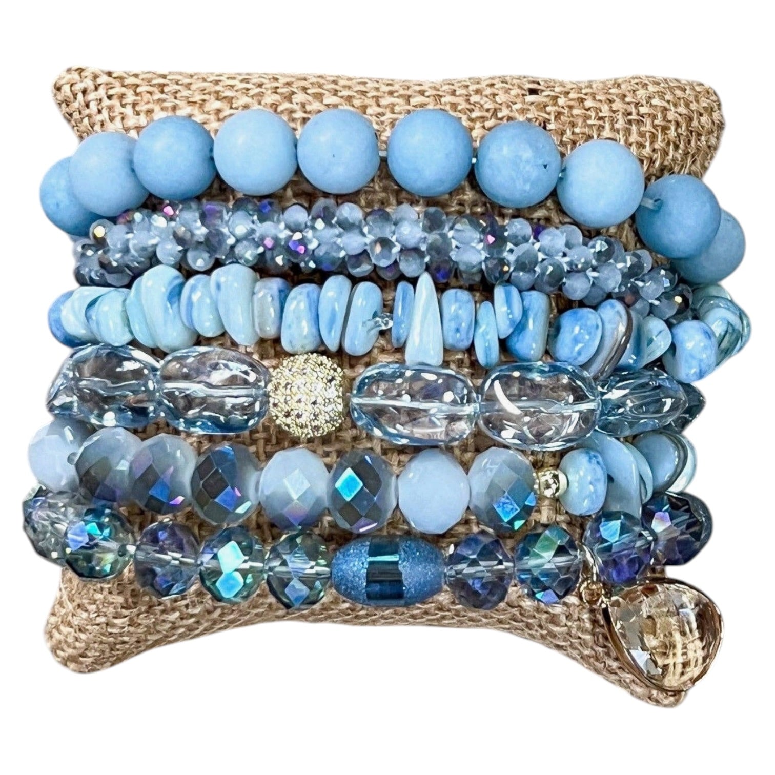 Stack of blue beaded bracelets on a textured surface
