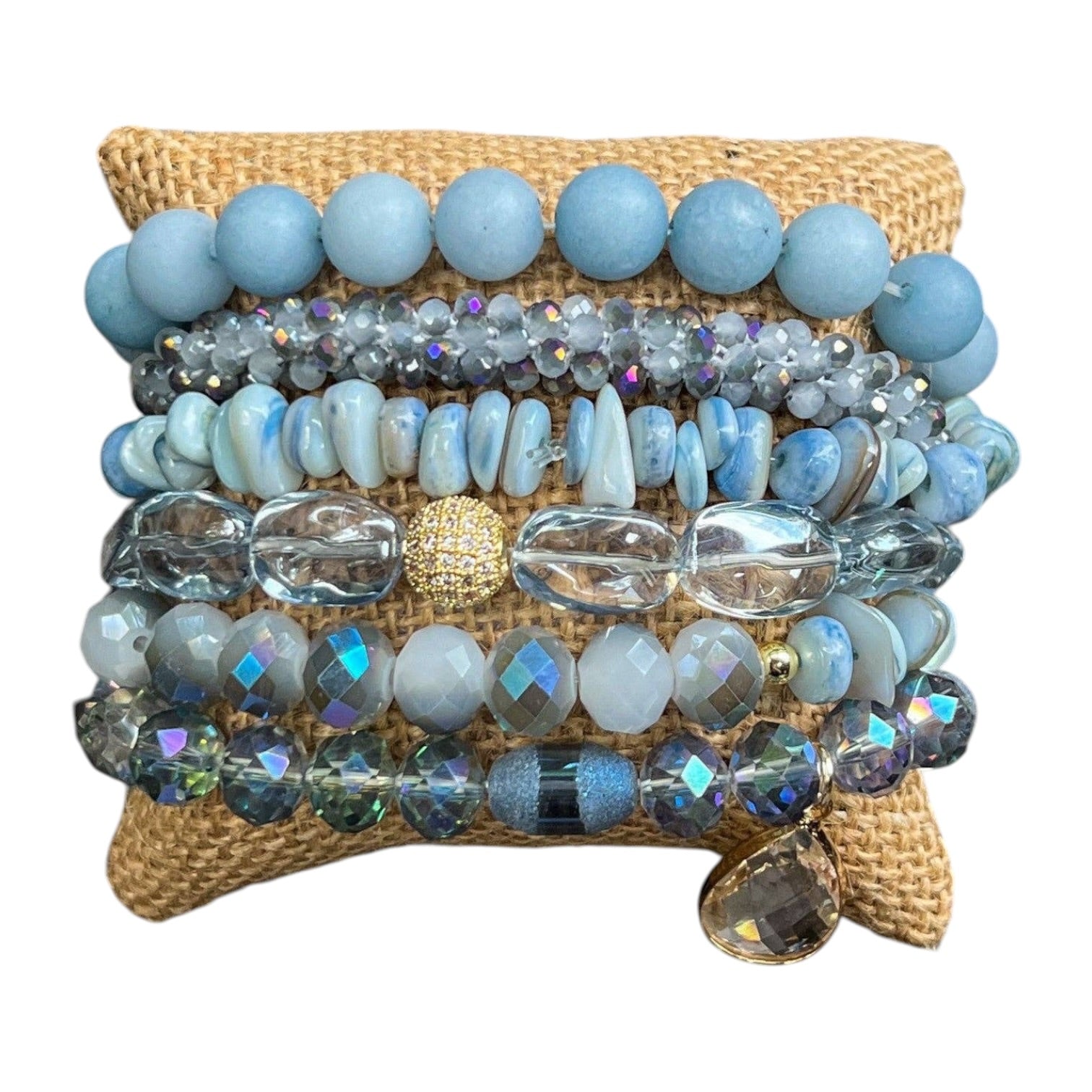 Stack of blue beaded bracelets on a woven mat