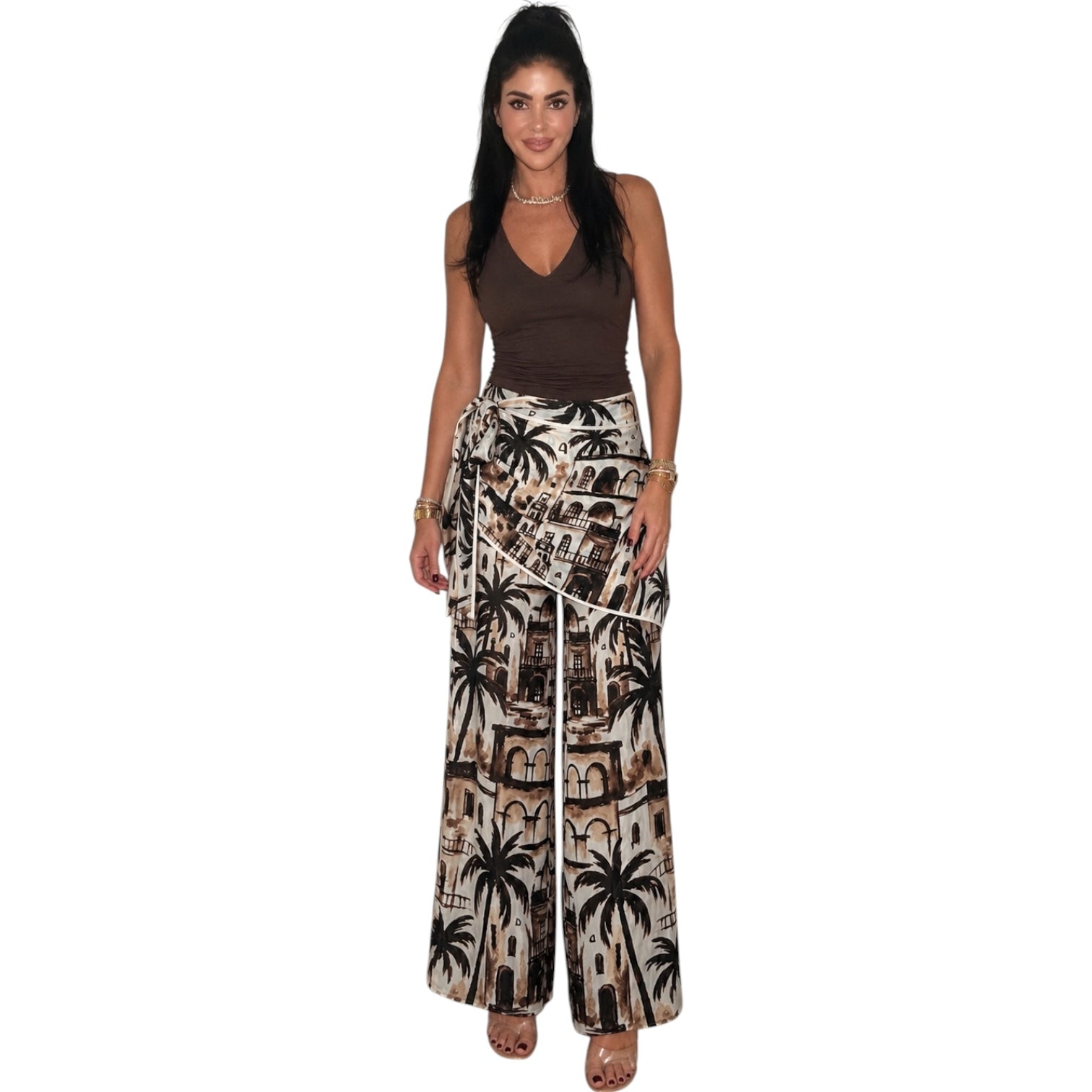 Woman wearing a brown top and patterned wide-leg pants on a white background