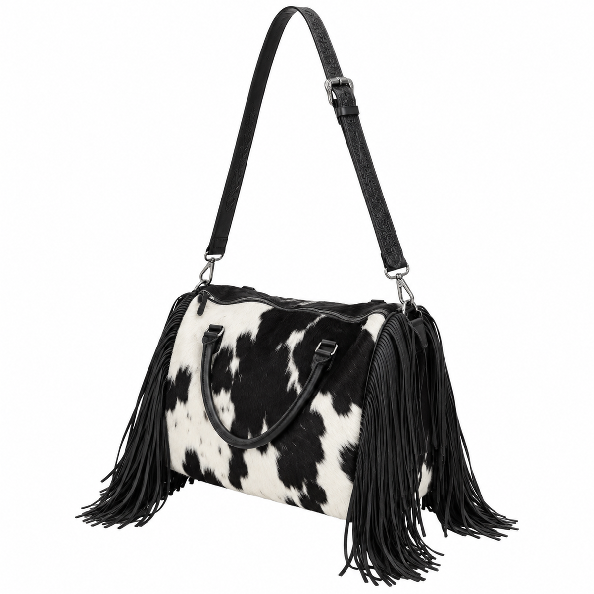 A black and white cow-print shoulder bag with long black fringe tassels and a black shoulder strap, shown on a plain white background.
