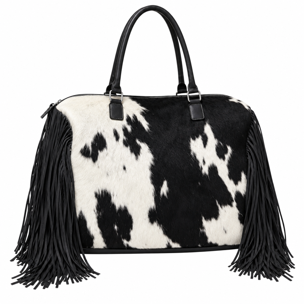 A black and white cowhide shoulder bag with long black fringe tassels hanging from the sides and black leather handles, shown against a plain white background.