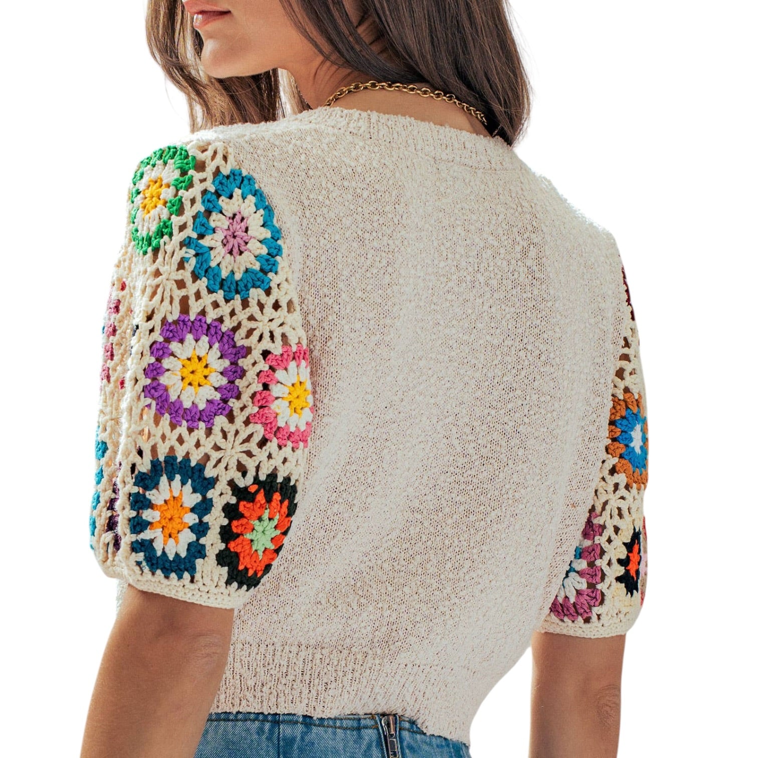 Beige knit cardigan with colorful floral patterns on sleeves and back against a white background
