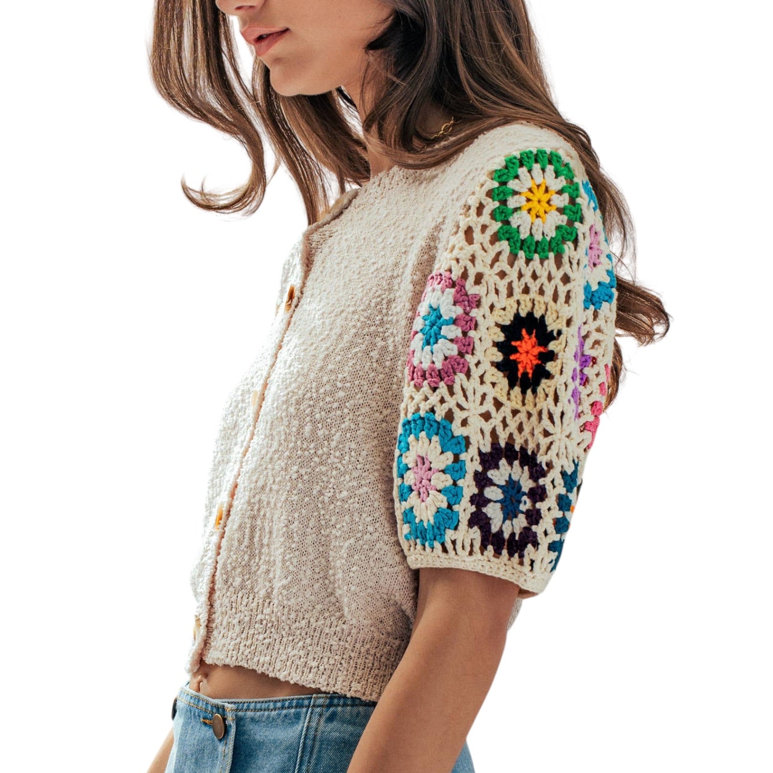 Woman wearing a colorful crochet cardigan with a white background