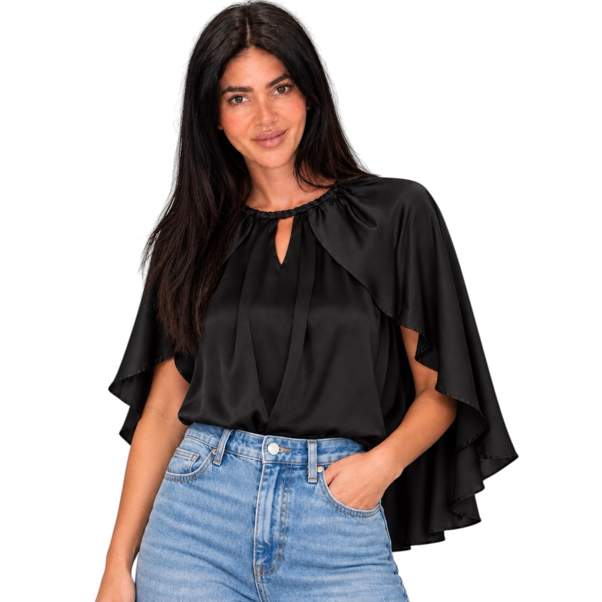 A woman modeling a black satin-like blouse with a keyhole neckline and dramatic draped cap sleeves, paired with light blue jeans against a plain white background.