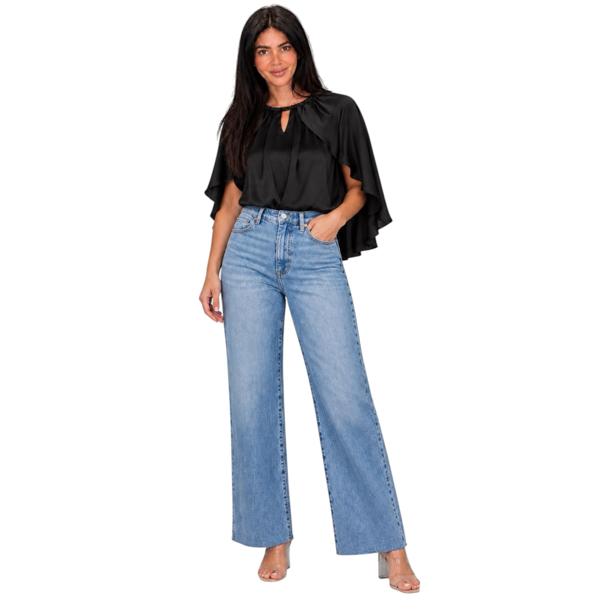 A woman modeling a black short-sleeve blouse with flutter sleeves and a keyhole neckline, paired with high-waisted, wide-leg light blue jeans, on a solid white background.