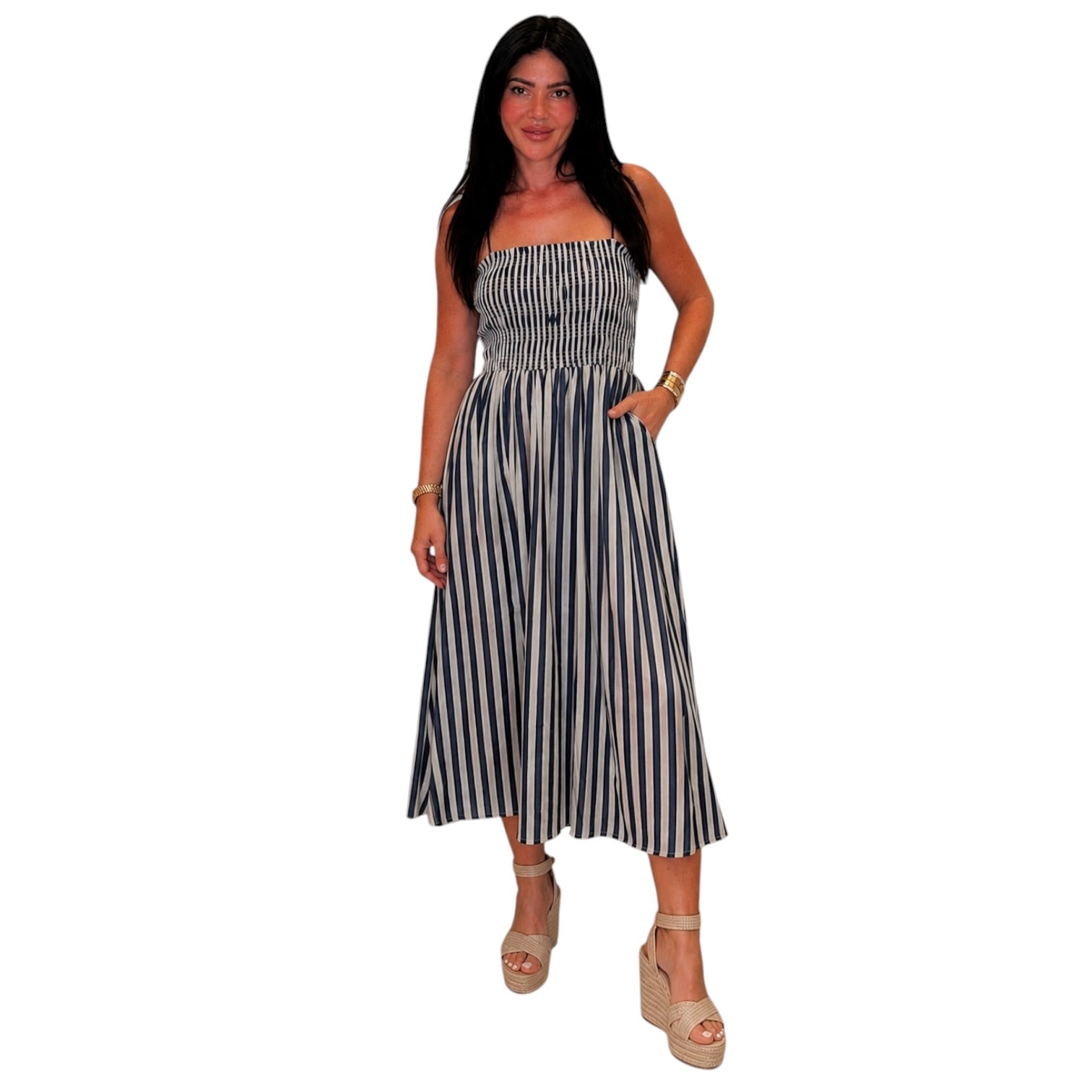 Woman wearing a denim and white striped dress on a white background