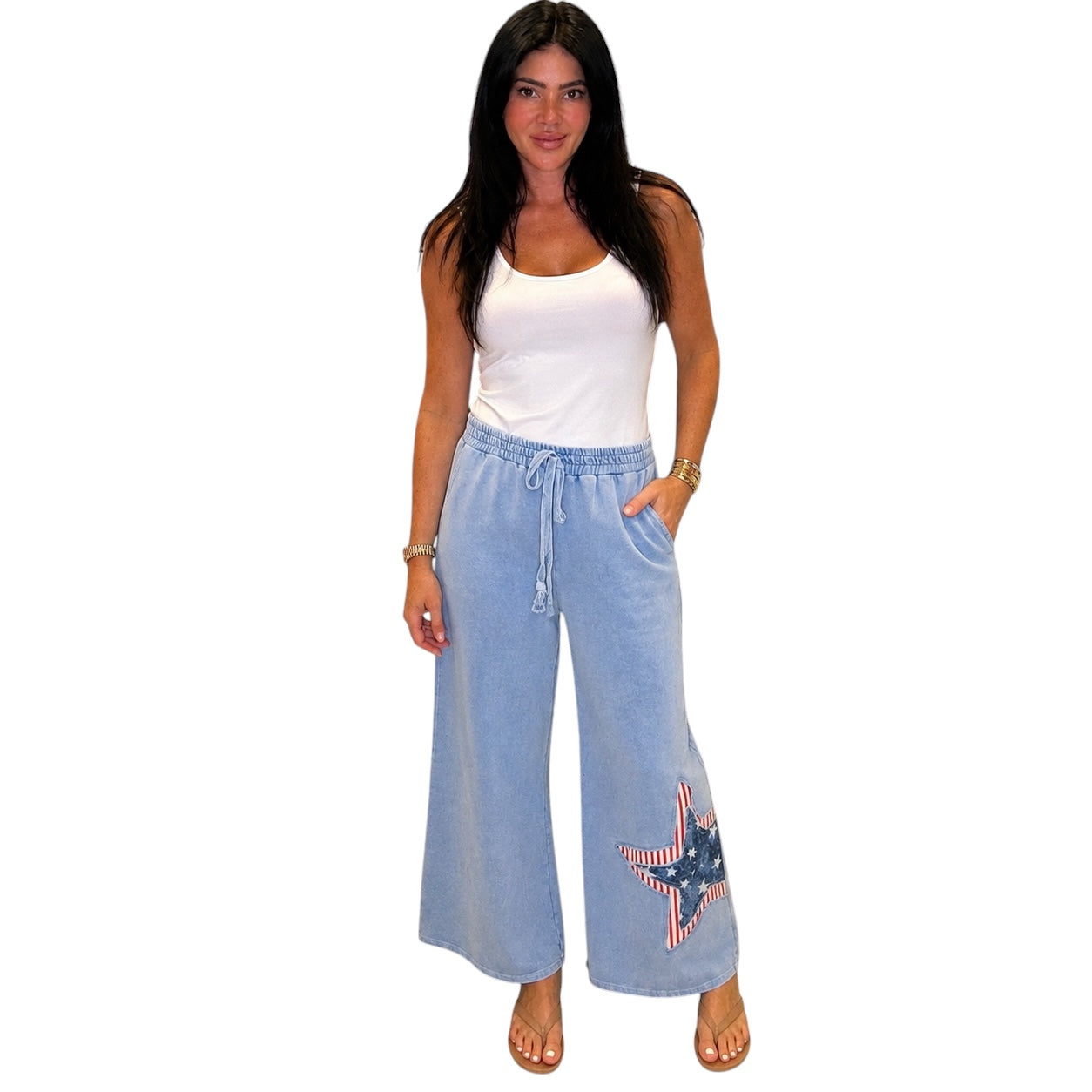 Woman wearing light blue denim pants with a star design on a white background