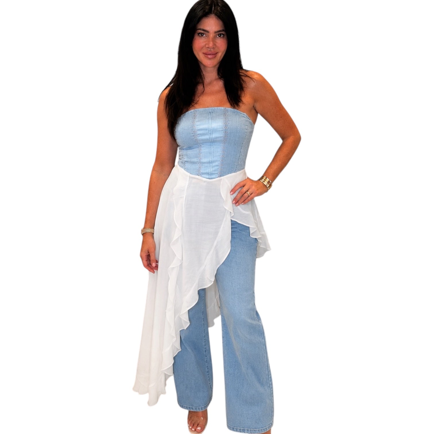 Woman wearing a light blue strapless maxi top and white flowing garment with blue jeans on a white background
