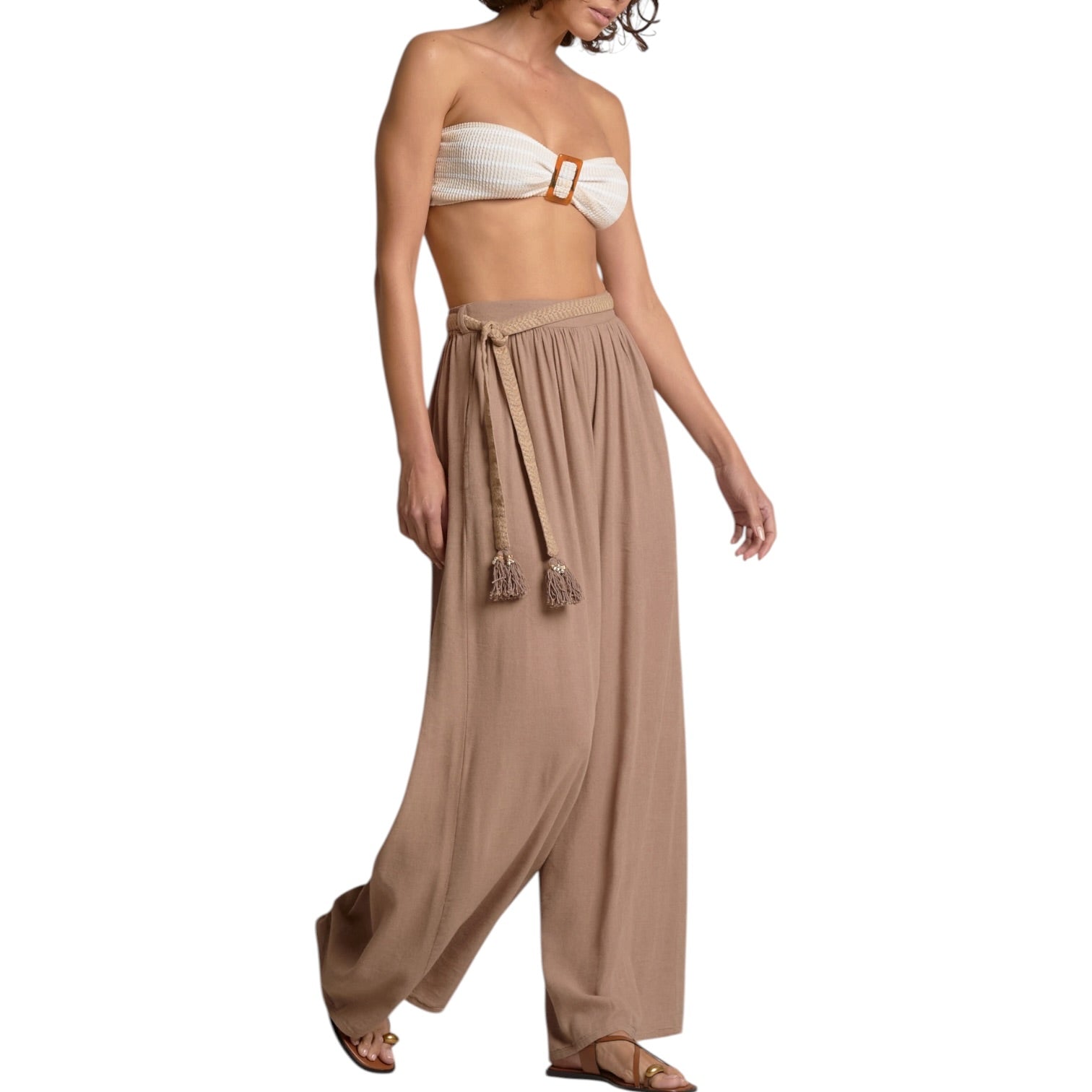 Woman wearing a strapless top and wide-leg pants on a white background