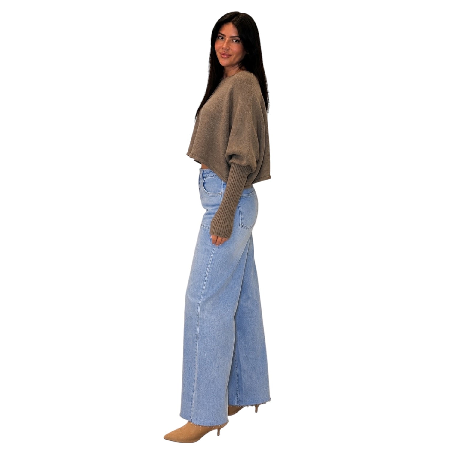 A woman modeling a taupe-brown knit cropped sweater with balloon sleeves and light-wash wide-leg denim jeans, shown from the back against a plain white background.