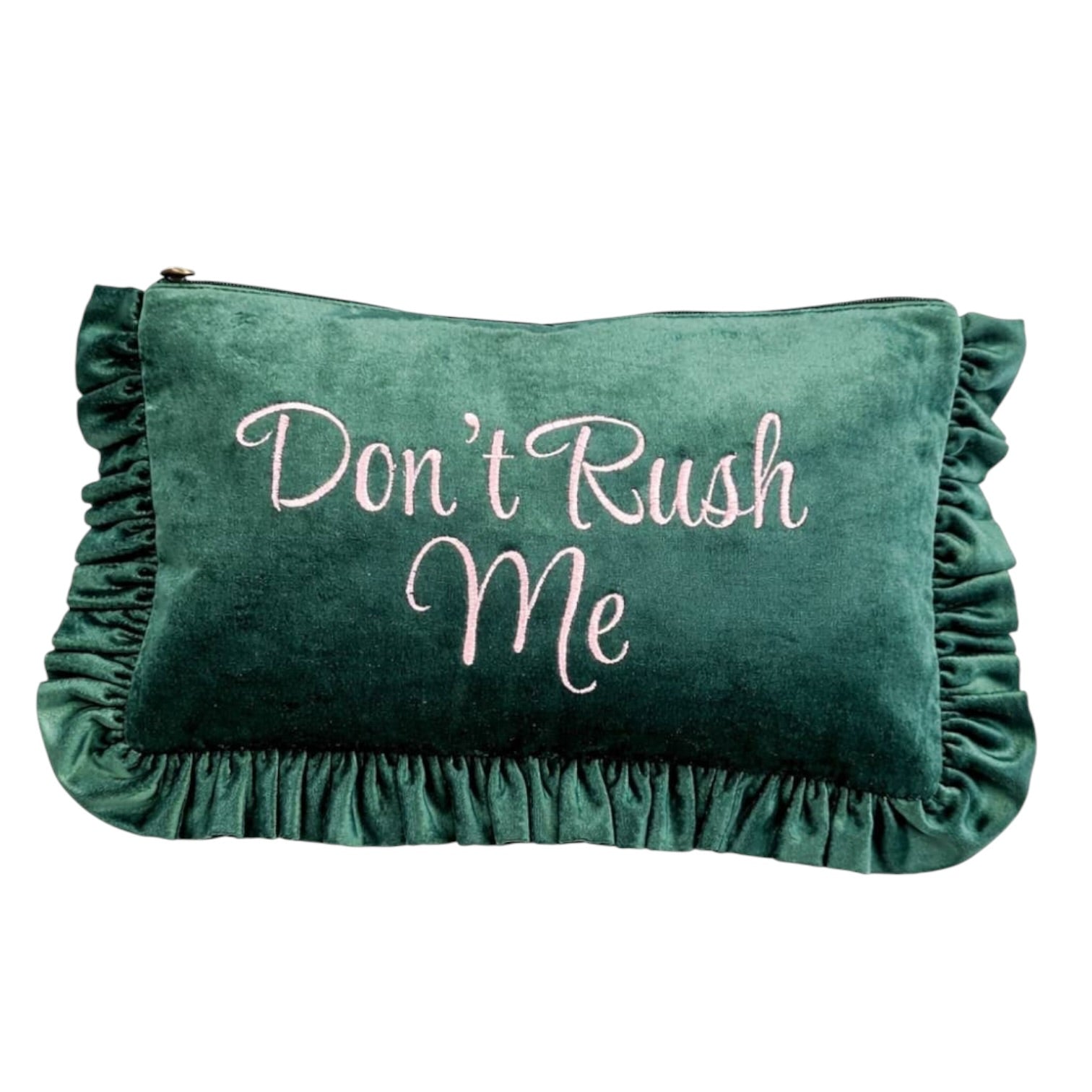 A dark green velvet clutch pouch with ruffled trim on all sides, featuring the phrase 'Don't Rush Me' embroidered in light pink script across the front.