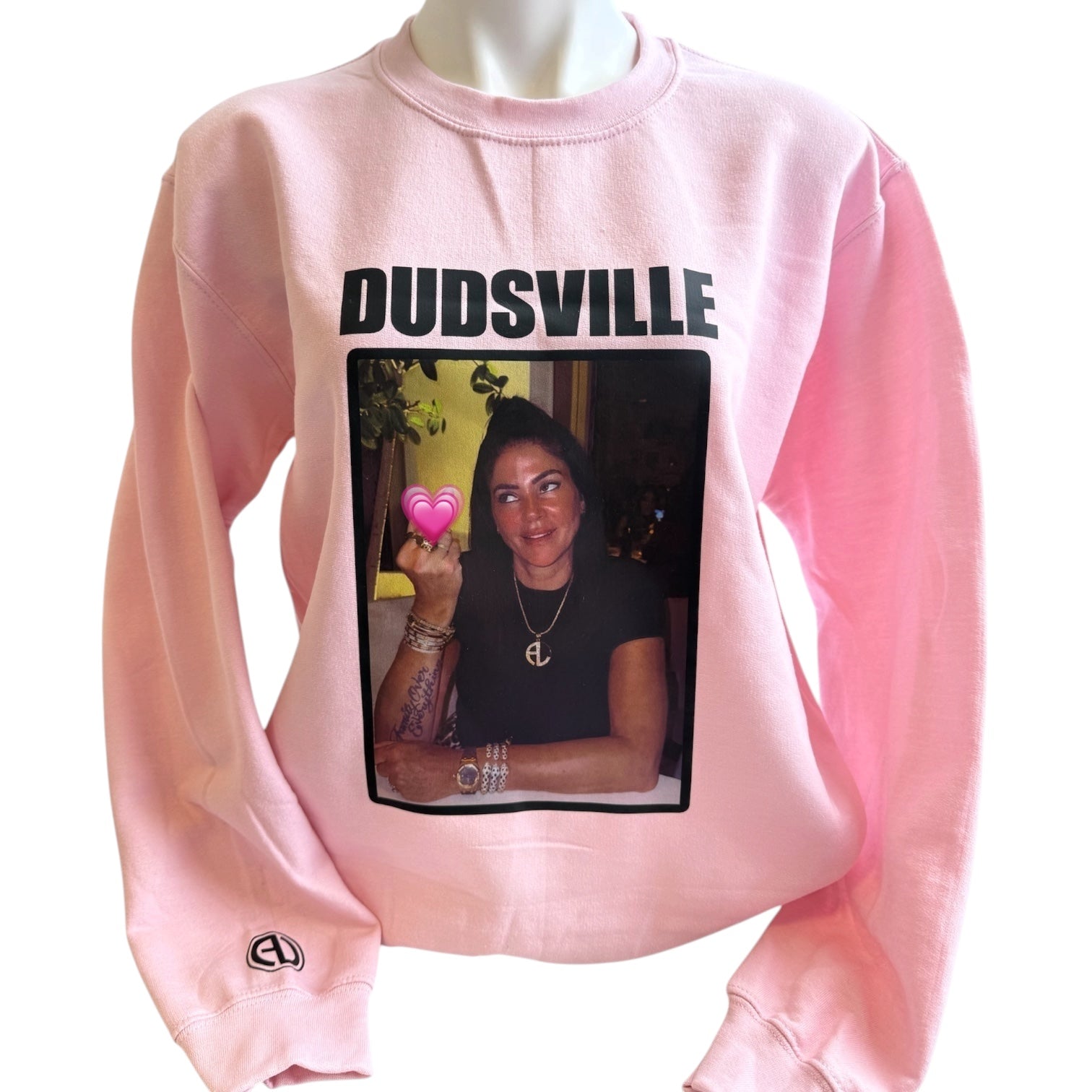 Pink sweatshirt with a graphic of a person holding a heart and 'DUDSVILLE' text on a white background