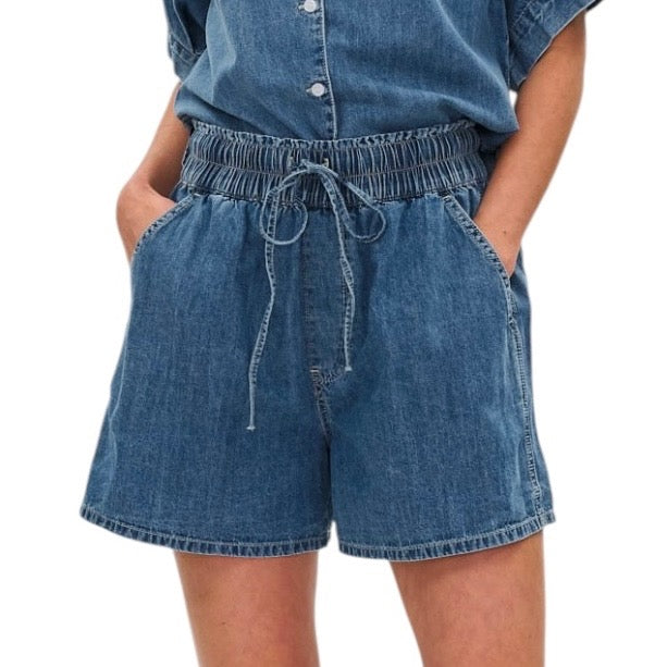 Blue denim shorts worn by a person on a white background