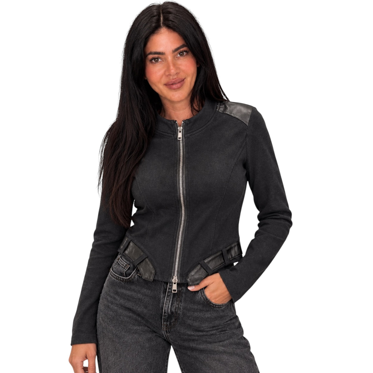 A woman modeling a black zip-front jacket with dark gray faux-leather shoulder and waist panel details, paired with dark gray jeans, against a plain white background.