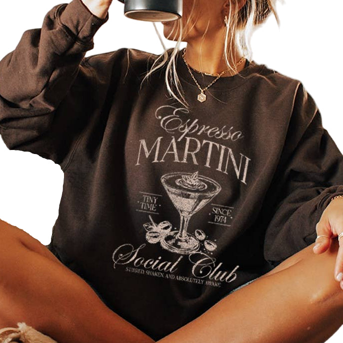 Person wearing a brown sweatshirt with 'Espresso Martini Social Club' design.