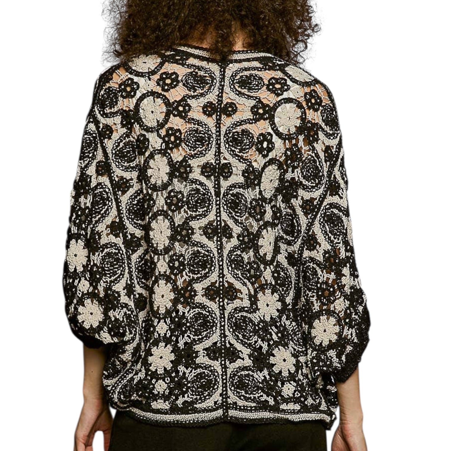 Person wearing a black and white patterned jacket on a white background