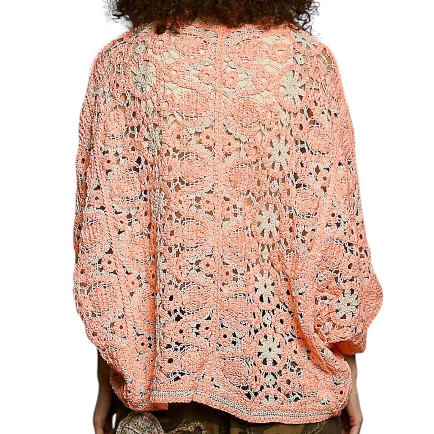 Person wearing a orange floral lace top on a white background