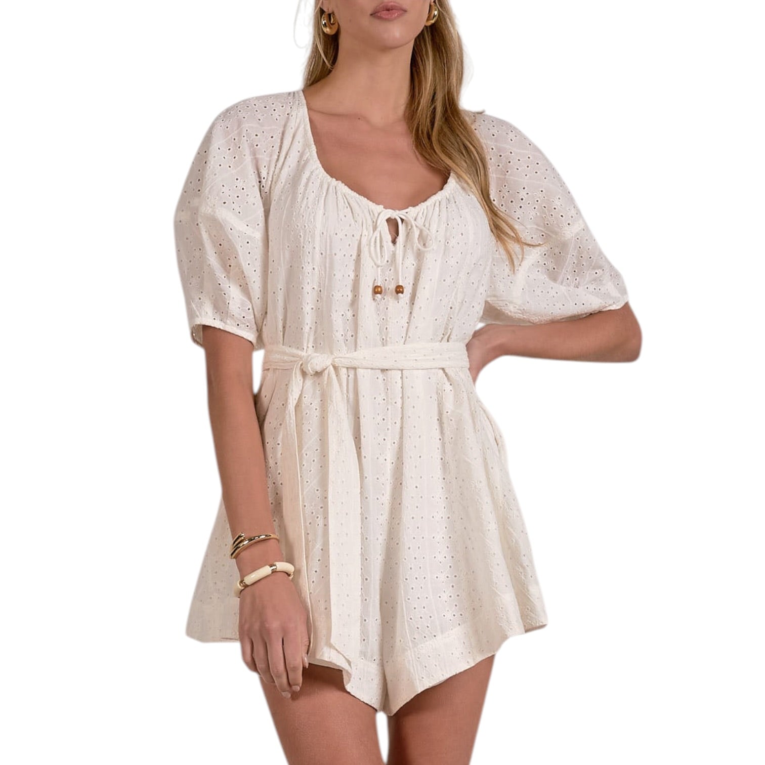 Woman wearing a white romper with a subtle pattern on a white background