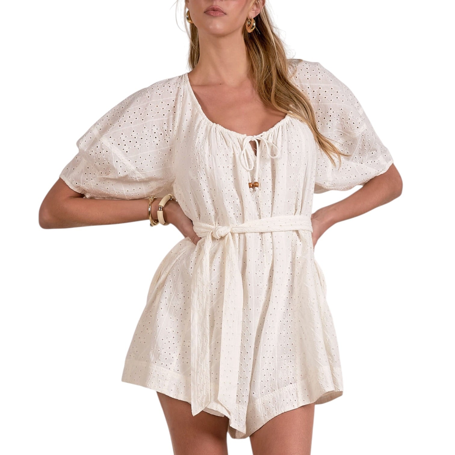 Woman wearing a white dress with a subtle pattern on a white background