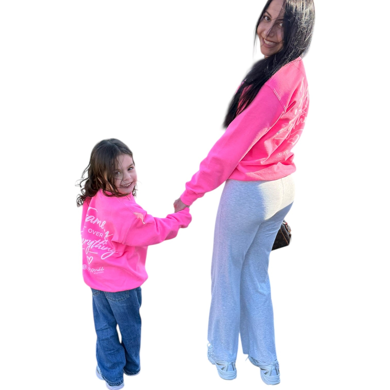 Woman and child wearing matching pink sweatshirts on a white background