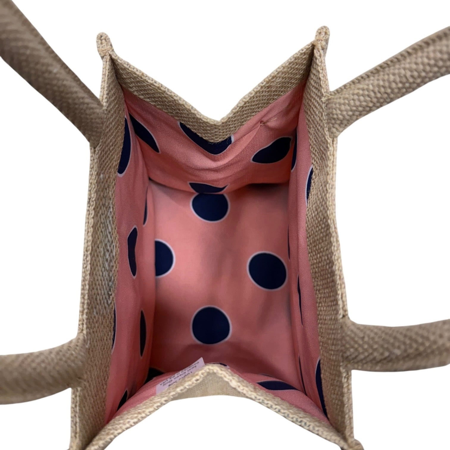 Close-up of a woven basket with a pink interior featuring blue polka dots.